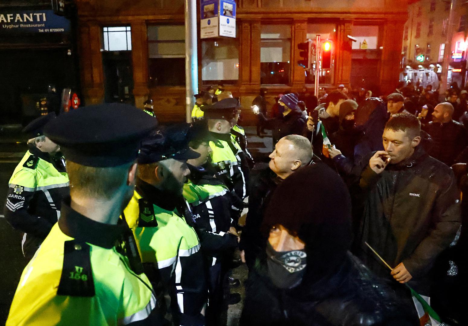 People stand in front of riot police near the scene of a suspected stabbing that left few children injured in Dublin, Ireland, November 23, 2023. REUTERS/Clodagh Kilcoyne Photo: Clodagh Kilcoyne/REUTERS