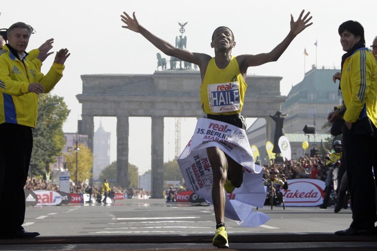 'Ethiopia\'s marathon runner Haile Gebrselassie crosses the finish line to set a new world record at the 35th Berlin marathon in Berlin September 28, 2008. Gebrselassie clocked 2:03.59. In the backgro