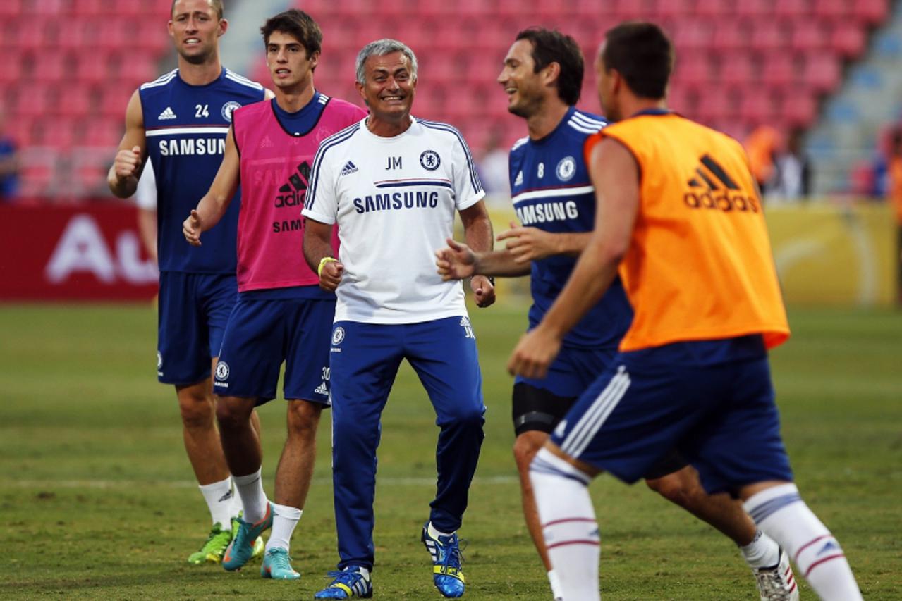 'Chelsea manager Jose Mourinho (C) jokes with his players Gary Cahill (L), Lucas Piazon (2nd L) and Frank Lampard (2nd R) during their training session in Bangkok July 16, 2013. Chelsea will face the 