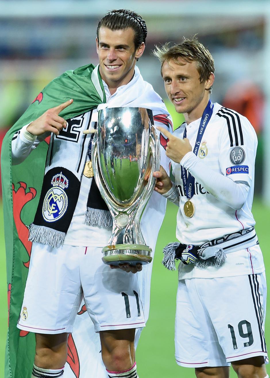 Soccer - 2014 UEFA Super Cup - Sevilla v Real Madrid - Cardiff City StadiumReal Madrid's Gareth Bale (left) and Luka Modric (right) with the trophy after winning the UEFA Super Cup Final at the Cardiff City Stadium, Cardiff.Joe Giddens Photo: Press Associ