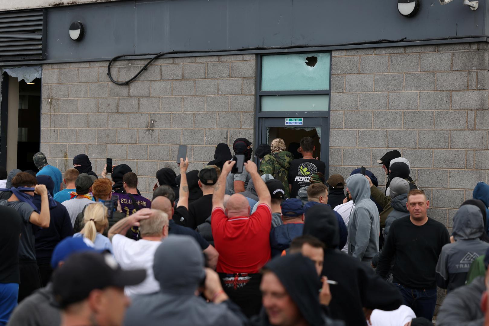 Protestors try to get inside a hotel through a damaged fire exit in Rotherham, Britain, August 4, 2024. REUTERS/Stringer Photo: STRINGER/REUTERS