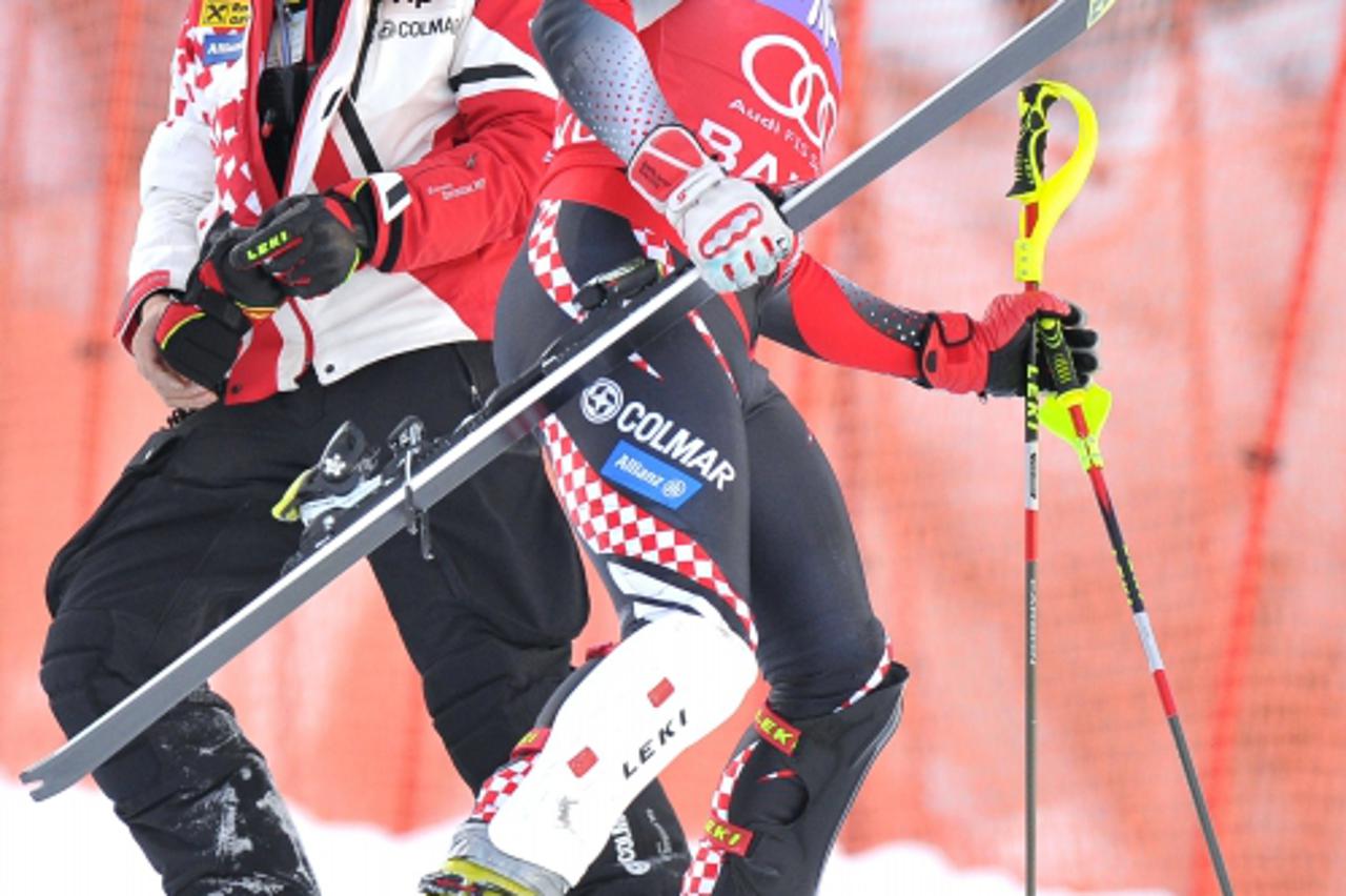 'Croatia\'s Ivica Kostelic, carrying one of his skis, leaves the slope after failling to finish the men\'s slalom during the FIS World Cup in Bansko on February 27, 2011.  AFP PHOTO / JOE KLAMAR'