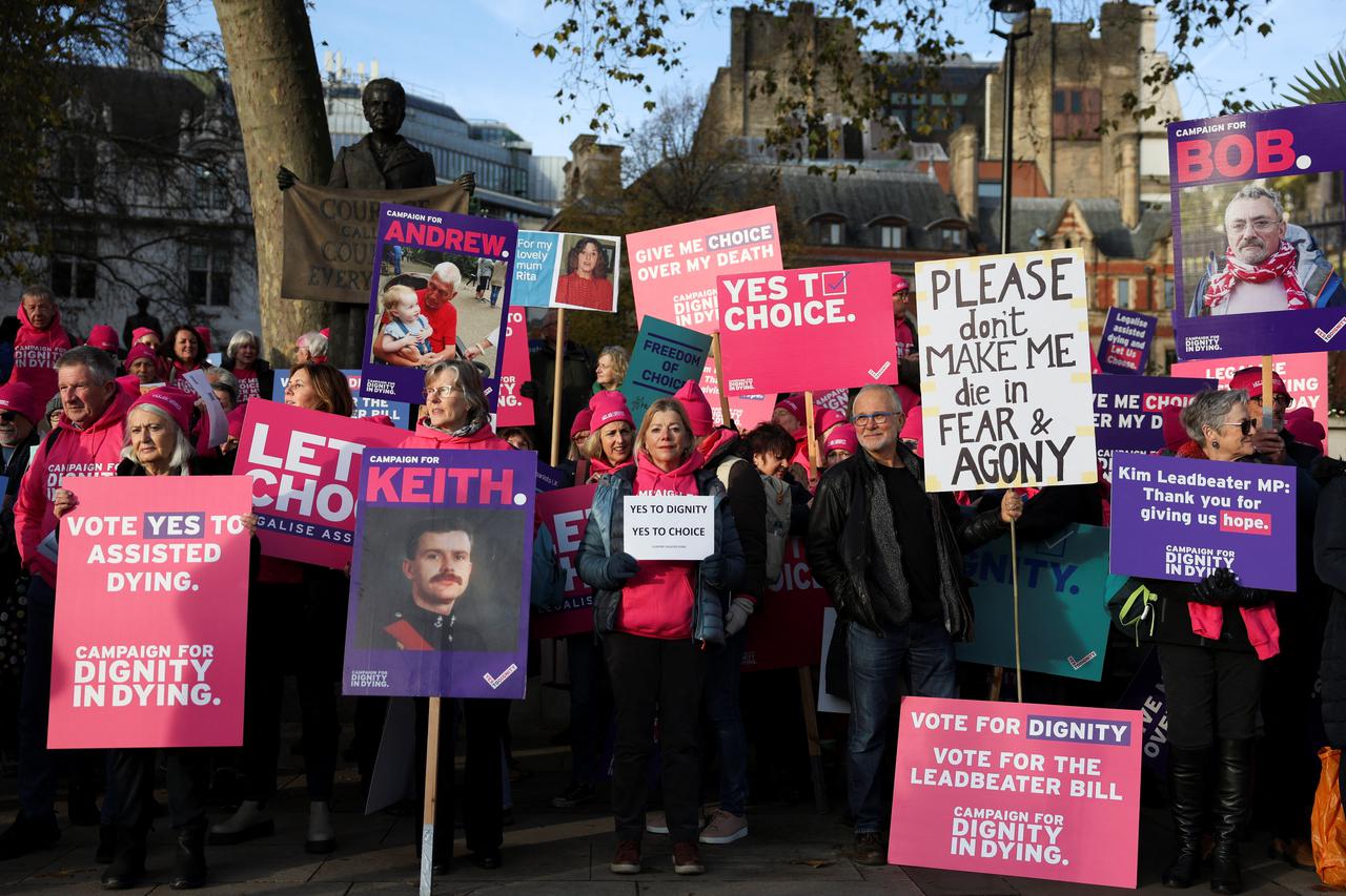 Protestors gather as British lawmakers debate the assisted dying law, in London