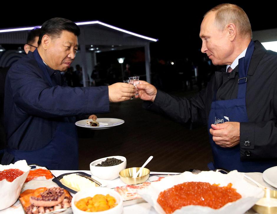 FILE PHOTO: Russian President Vladimir Putin and Chinese President Xi Jinping toast during a visit to the Far East Street exhibition on the sidelines of the Eastern Economic Forum in Vladivostok