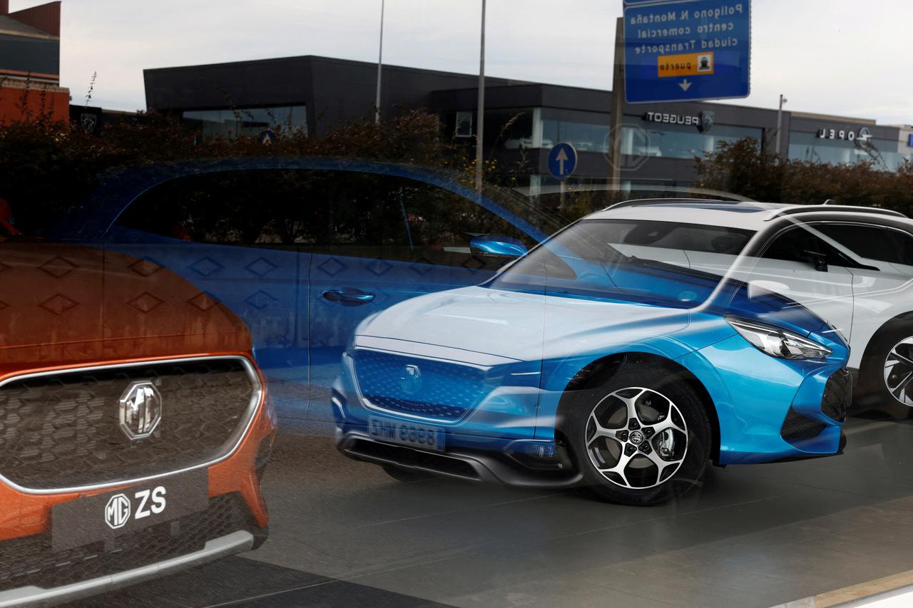 FILE PHOTO: MG Motor vehicles are seen reflected in the glass of a car showroom in Santander,