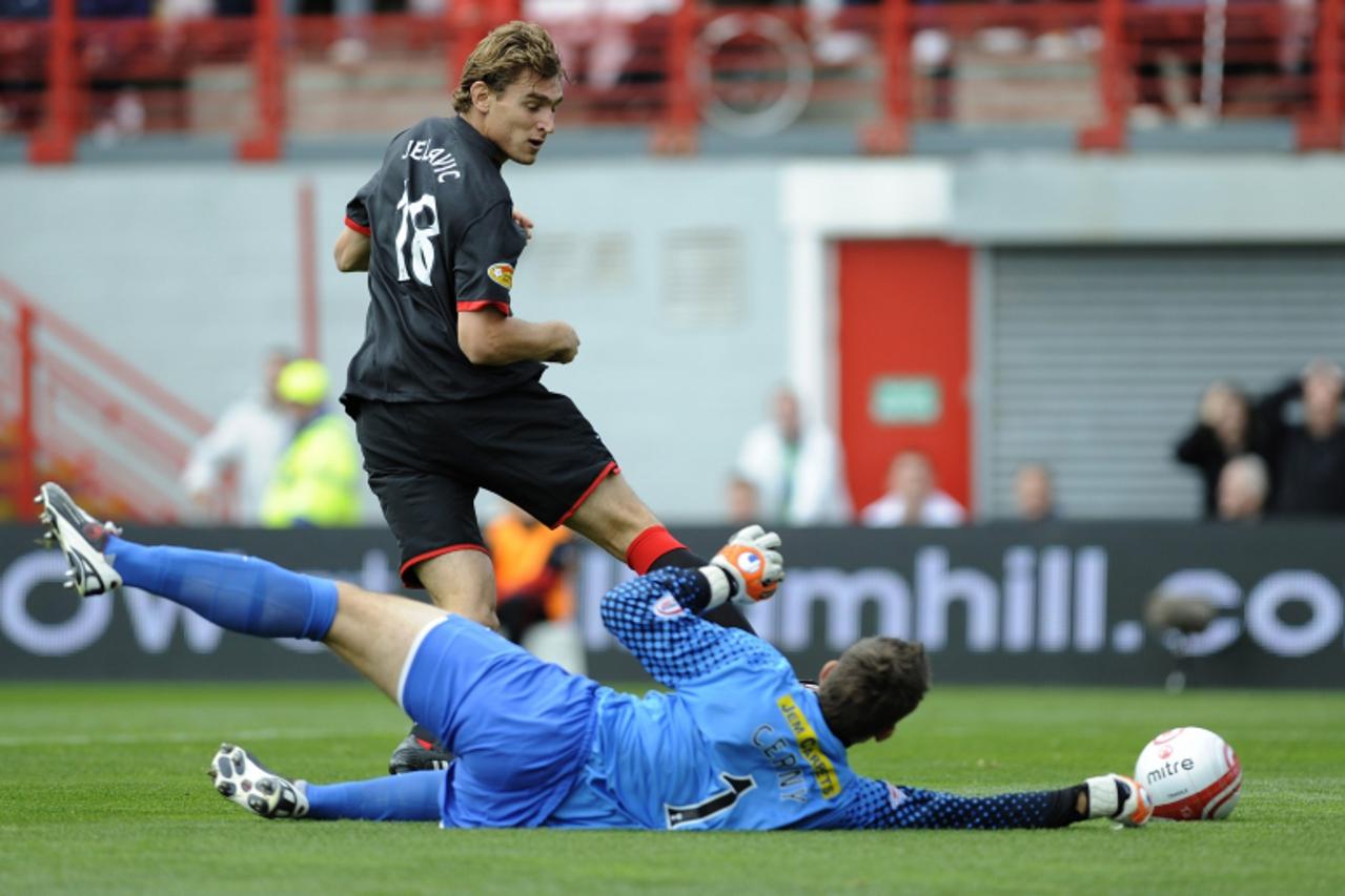 'Rangers\' Nikica Jelavic shoots as he is challenged by Hamilton\'s Tomas Cerney during their Scottish Premier League soccer match at New Douglas Park, Hamilton, Scotland, September 11, 2010. REUTERS/