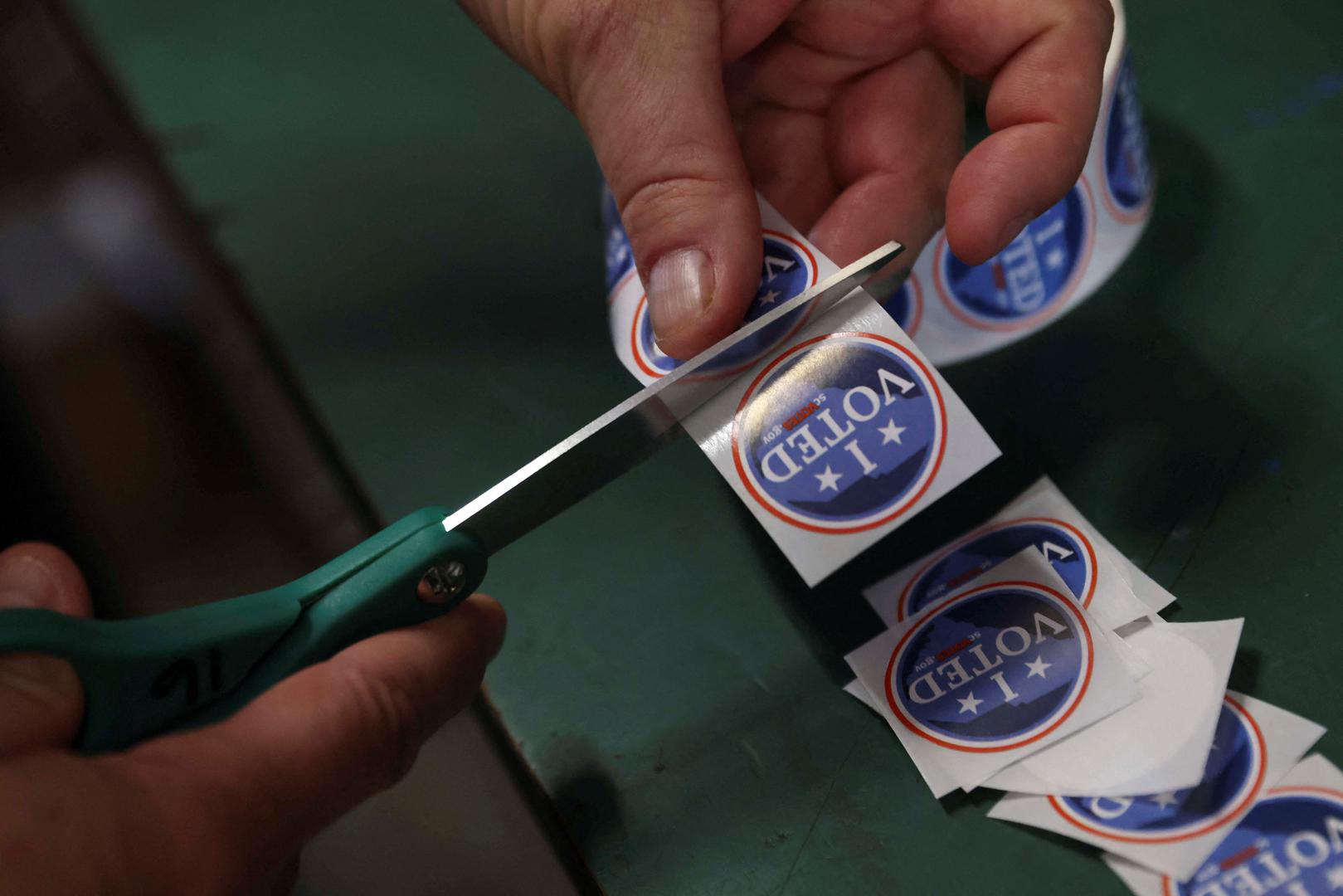 A pole worker cuts stickers at the Northlake Fire Station during the Republican presidential primary election on Election Day, in Cayce, South Carolina, U.S. February 24, 2024. REUTERS/Alyssa Pointer Photo: Alyssa Pointer/REUTERS