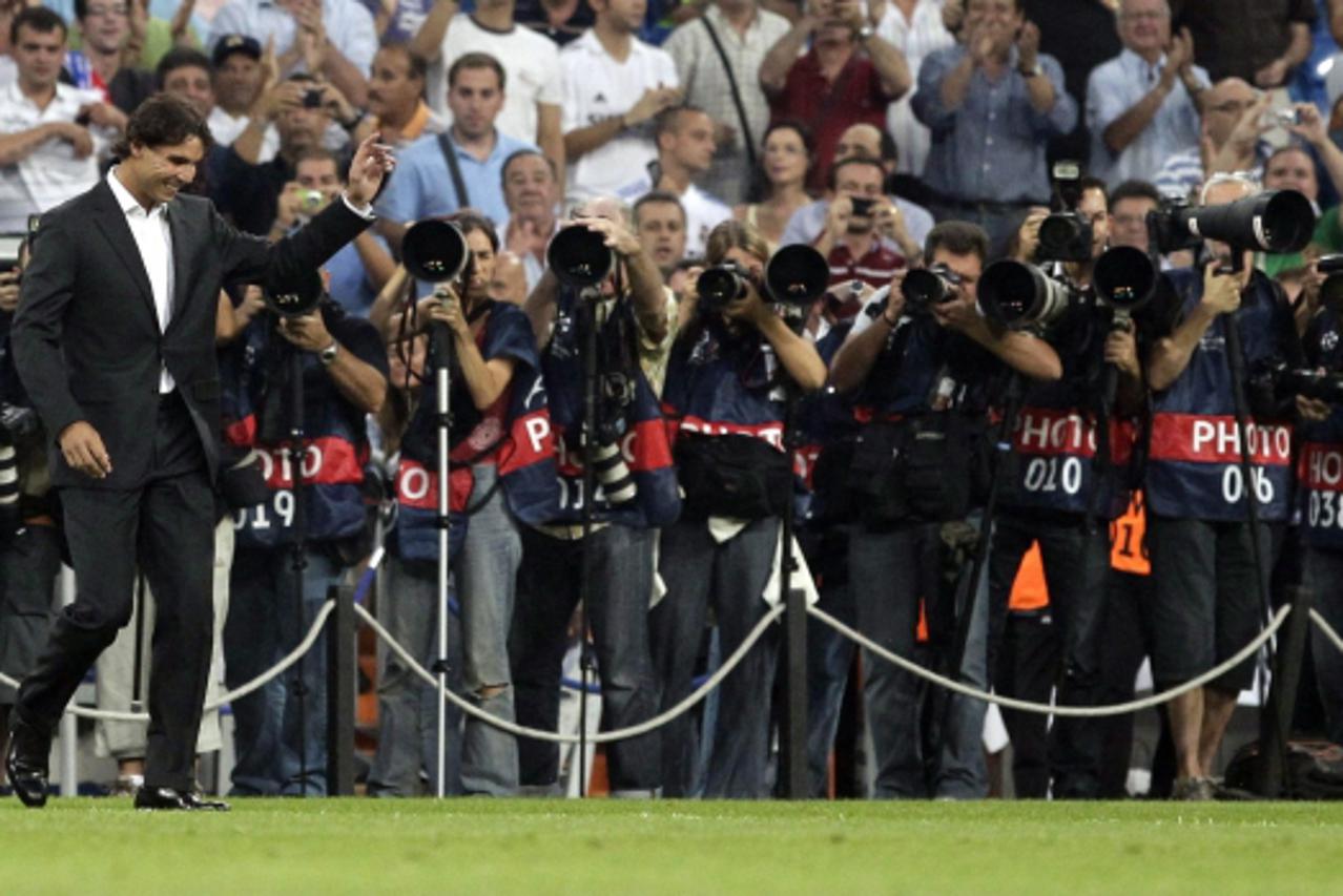 'Spain\'s Rafael Nadal waves to the crowd at the Santiago Bernabeu stadium before the start of a Champions League soccer match between Real Madrid and Ajax, in Madrid, September 15, 2010. REUTERS/Juan