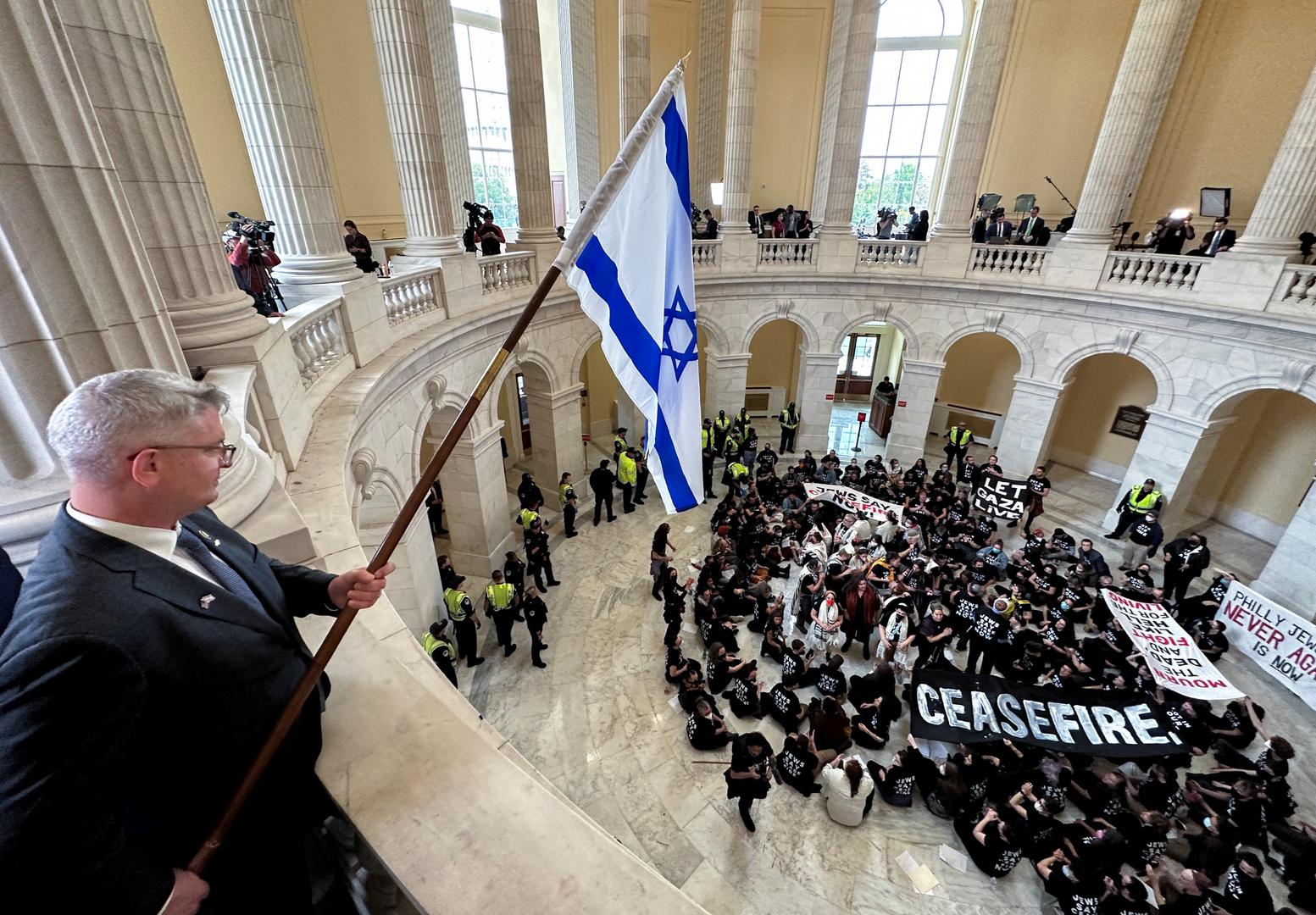 Rep. Brandon Williams (R-NY) dangles an Israeli flag over protesters, many of whom said they are Jewish, as they hold a civil disobedience action calling for a cease fire in Gaza and an end to the Israel-Hamas conflict while occupying the rotunda of the Cannon House office building on Capitol Hill in Washington, U.S., October 18, 2023. REUTERS/Jonathan Ernst Photo: JONATHAN ERNST/REUTERS