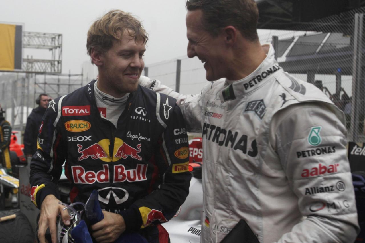 'Mercedes Formula One driver Michael Schumacher of Germany (R) congratulates compatriot Red Bull driver Sebastian Vettel after the Brazilian F1 Grand Prix at Interlagos circuit in Sao Paulo November 2