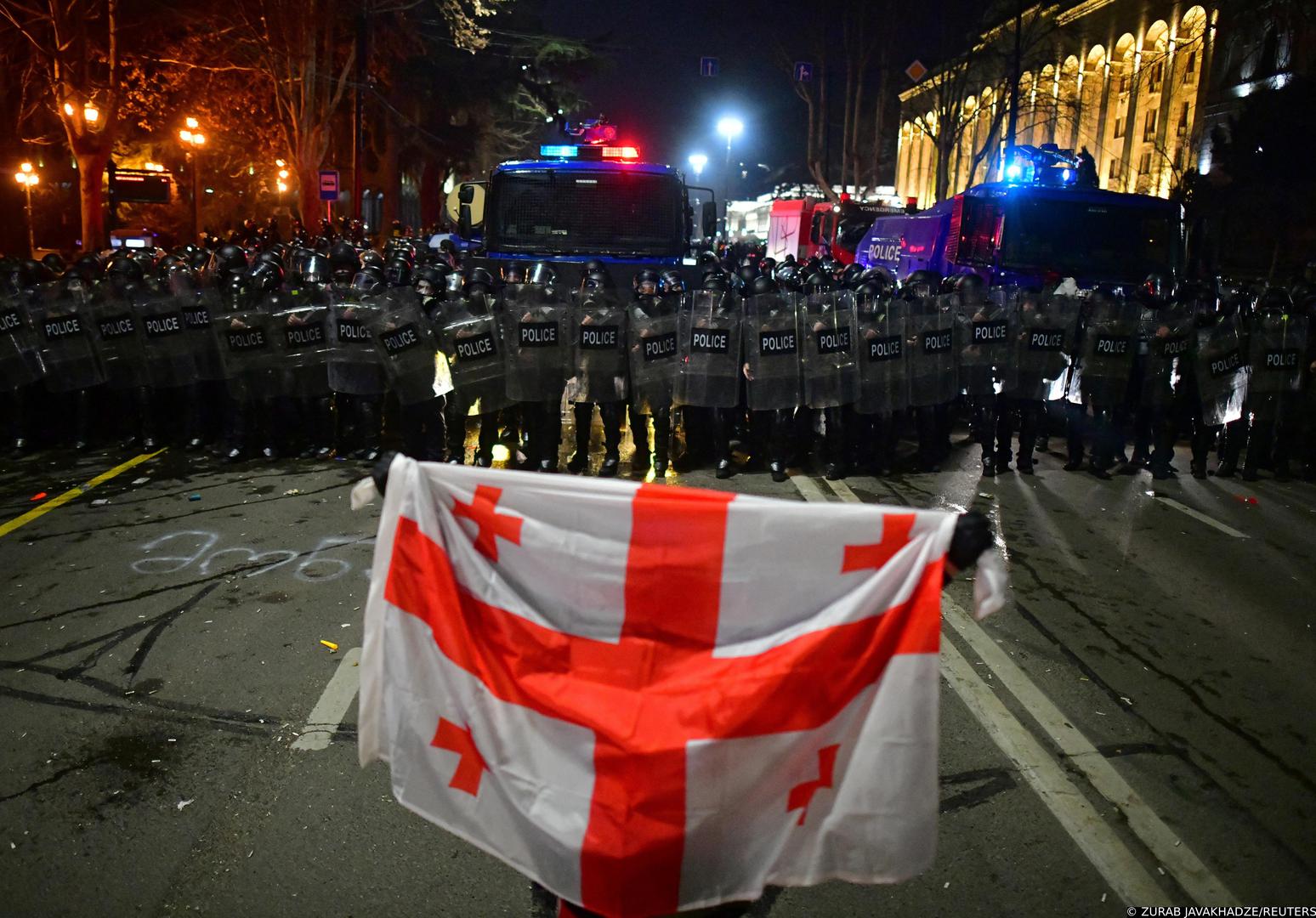 A demonstrator holds a Georgian flag in front of police officers during a protest against a draft law on "foreign agents", which critics say represents an authoritarian shift and could hurt Georgia's bid to join the European Union, in Tbilisi, Georgia, March 9, 2023. REUTERS/Zurab Javakhadze Photo: ZURAB JAVAKHADZE/REUTERS