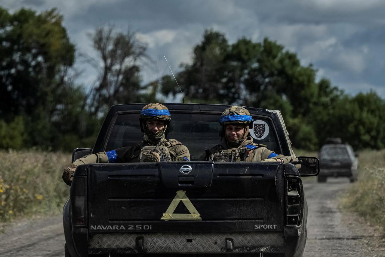 Ukrainian servicemen ride a military vehicle near the Russian border in Sumy region