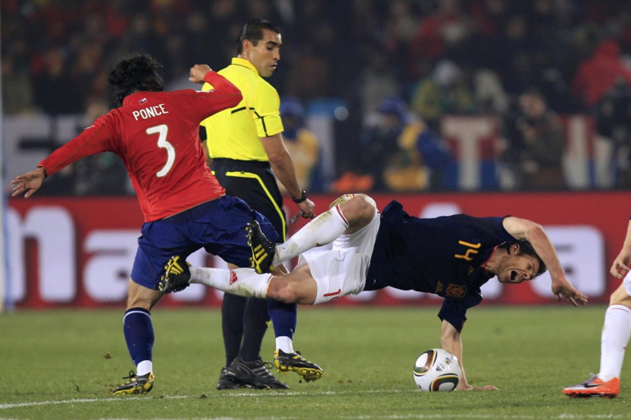 'Spain\'s Xabi Alonso (R) falls while fighting for the ball with Chile\'s Mauricio Isla during a 2010 World Cup Group H match  at Loftus Versfeld stadium in Pretoria June 25, 2010        REUTERS/Marce