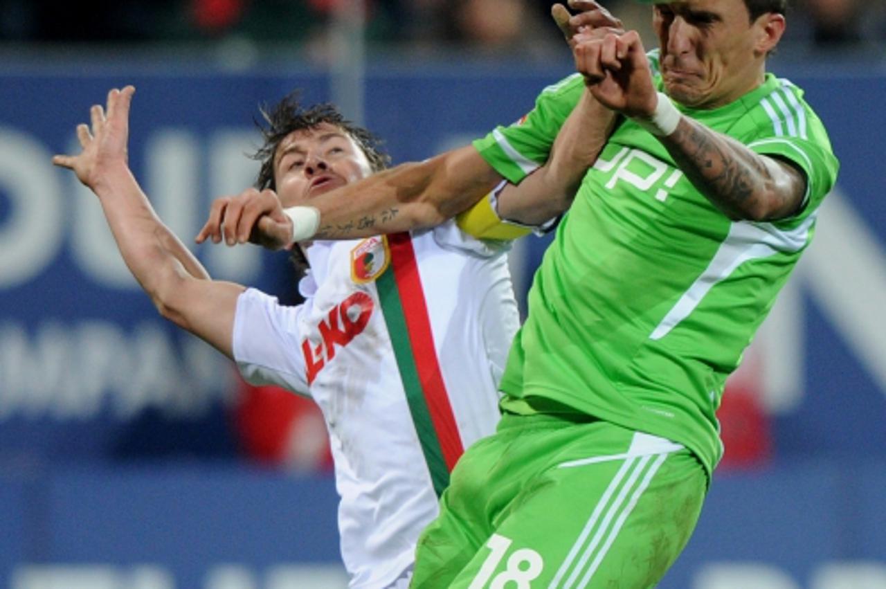 'Wolfsburg\'s Croatian striker Mario Mandzukic (R) and Augsburg\'s Dutch defender Paul Verhaegh vie for the ball during the German first division Bundesliga football match FC Augsburg vs VfL Wolfsburg