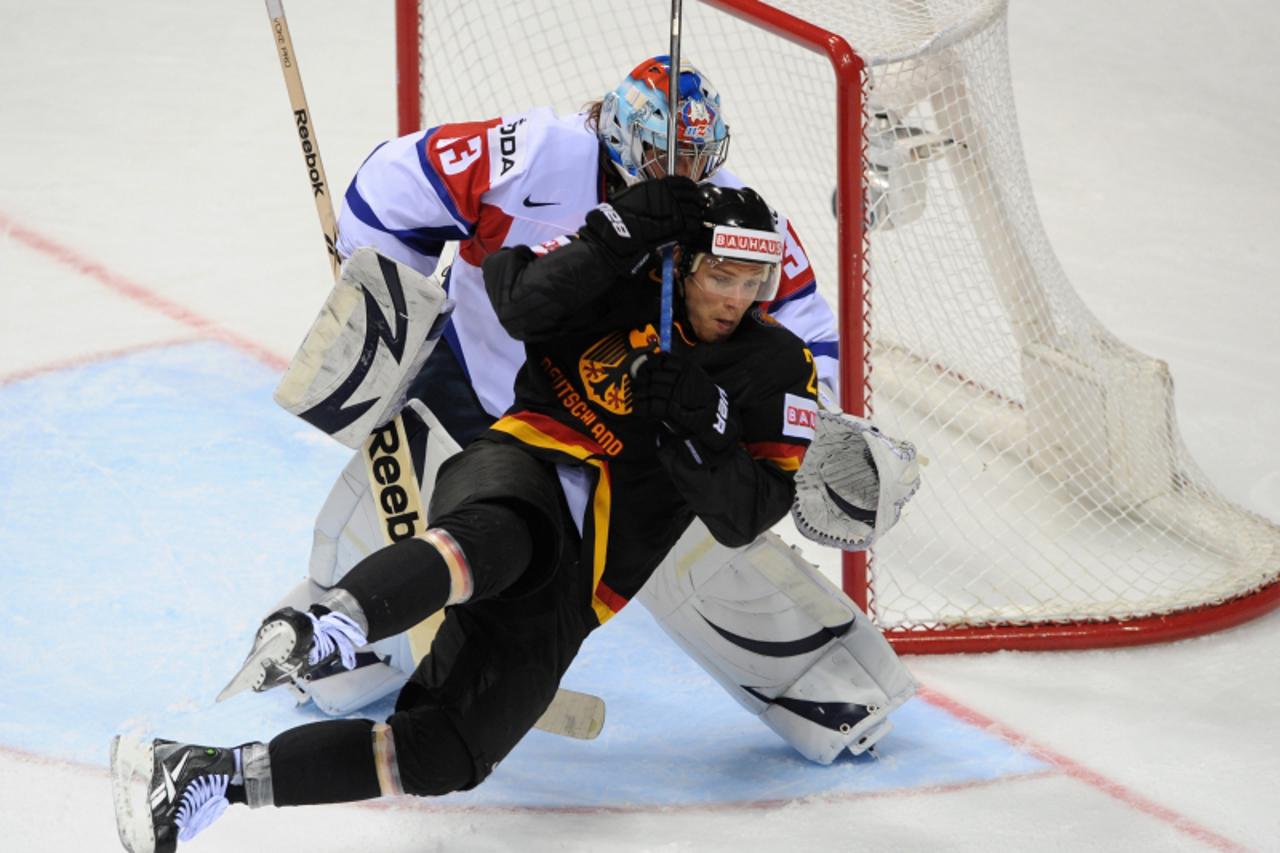 \'Germany\'s Alexander Barta (front)  fights for the puck with goalkeeper Robert Kristan of Slovenia during the IIHF Ice Hockey World Championship group A match in Bratislava, on May 3, 2011.AFP PHOTO