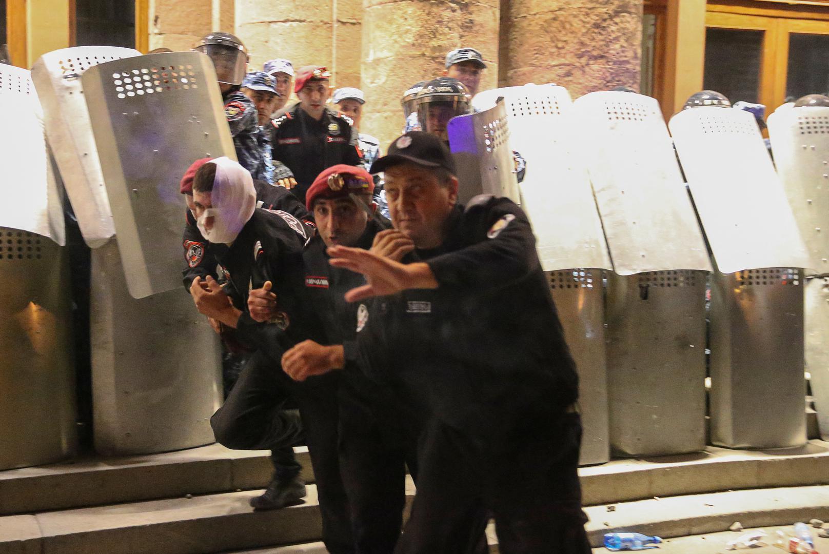 Law enforcement officers take cover as protesters throw objects towards the government building during a rally to support ethnic Armenians in Nagorno-Karabakh following Azerbaijani armed forces' offensive operation executed in the region, in Yerevan, Armenia, September 20, 2023. REUTERS/Irakli Gedenidze Photo: IRAKLI GEDENIDZE/REUTERS