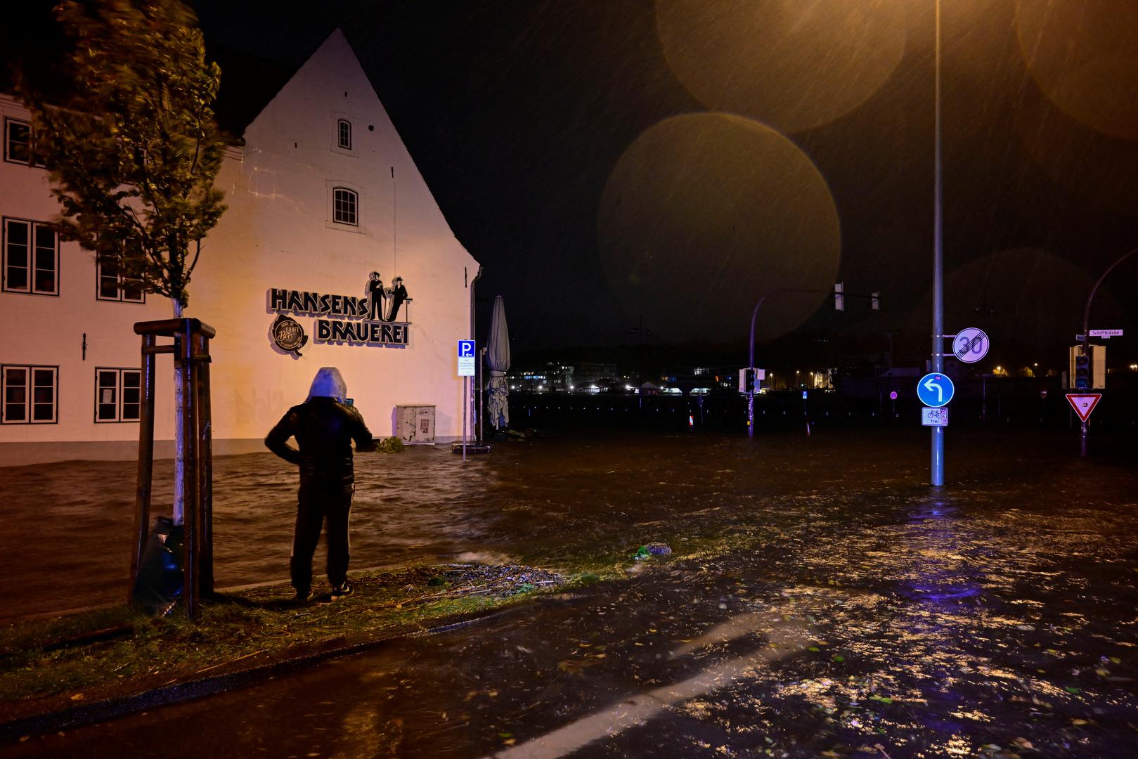 A person stands in the flooded street, as the Baltic Sea coast is hit by heavy storms, in Flensburg, northern Germany, October 20, 2023. REUTERS/Fabian Bimmer Photo: Fabian Bimmer/REUTERS