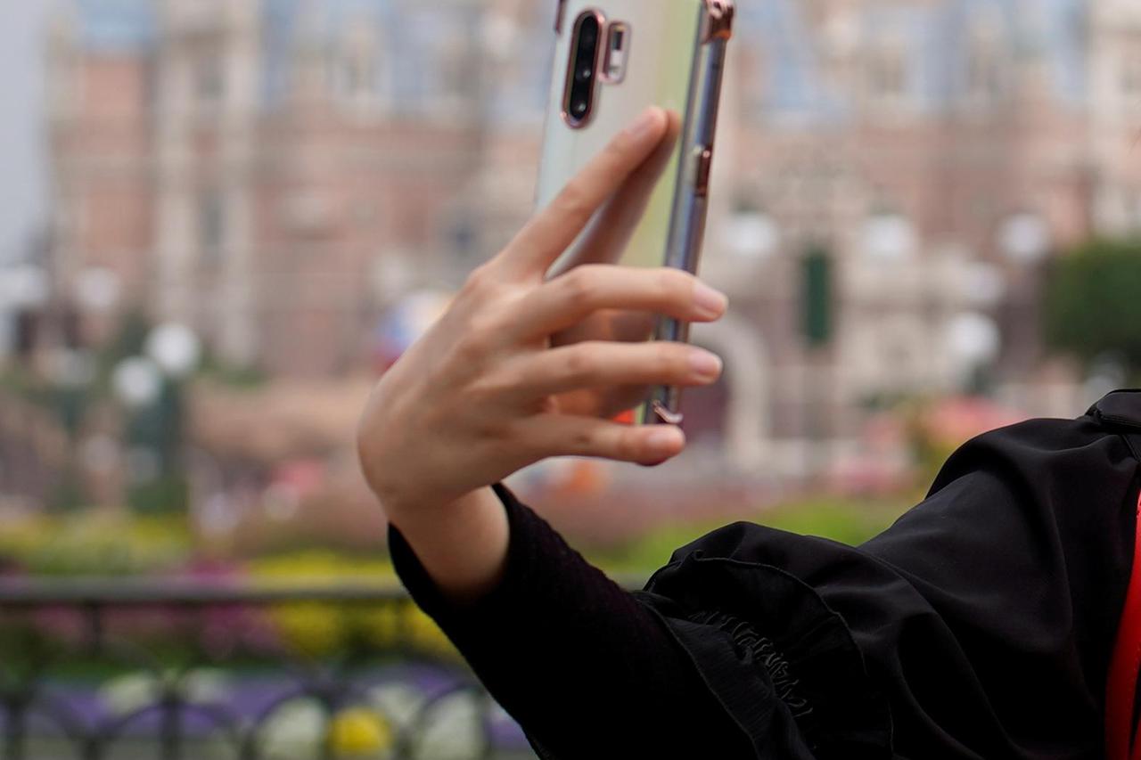 A visitor dressed as a Disney character takes a selfie while wearing a protective face mask at Shanghai Disney Resort as the Shanghai Disneyland theme park reopens following a shutdown due to the coronavirus disease (COVID-19) outbreak, in Shanghai