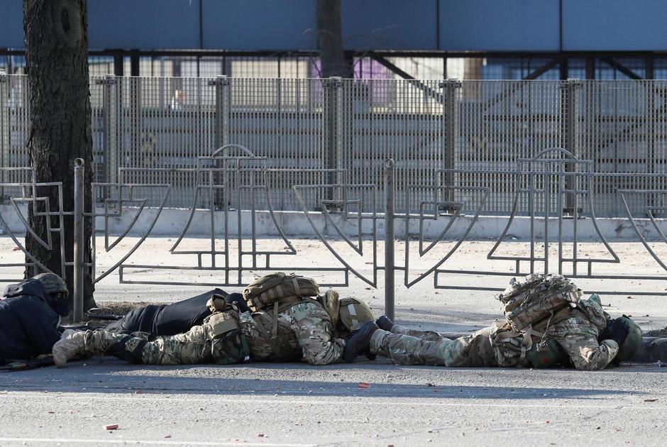 Ukrainian servicemen take cover as an air-raid siren sounds in Kyiv