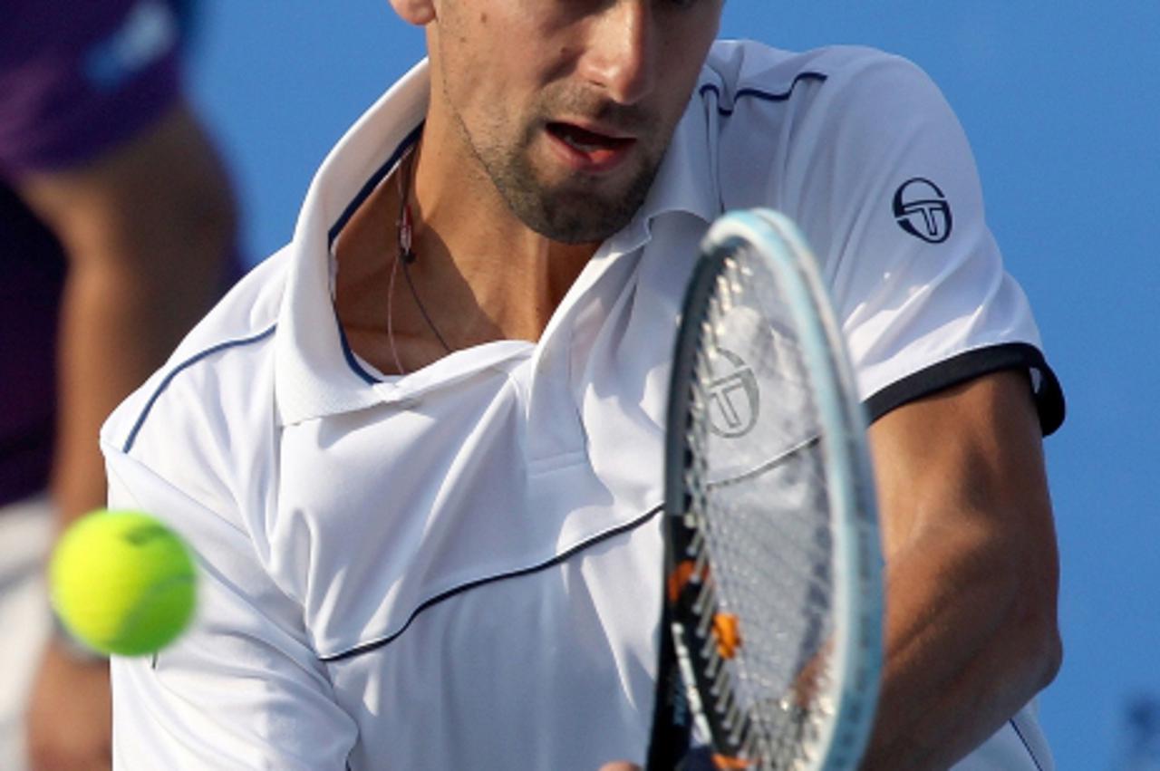 'World number one Novak Djokovic of Serbia returns the ball to Roger Federer of Switzerland during their Mubadala World Tennis Champisonship semi-final match in Abu Dhabi on December 30, 2011. Djokovi