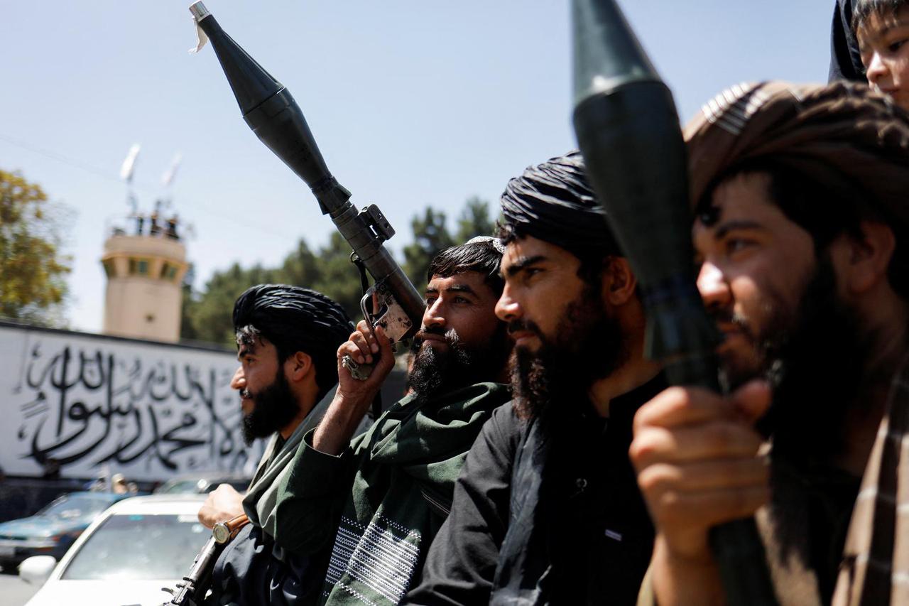 Taliban soldiers celebrate on the second anniversary of the fall of Kabul on a street near the US embassy in Kabul