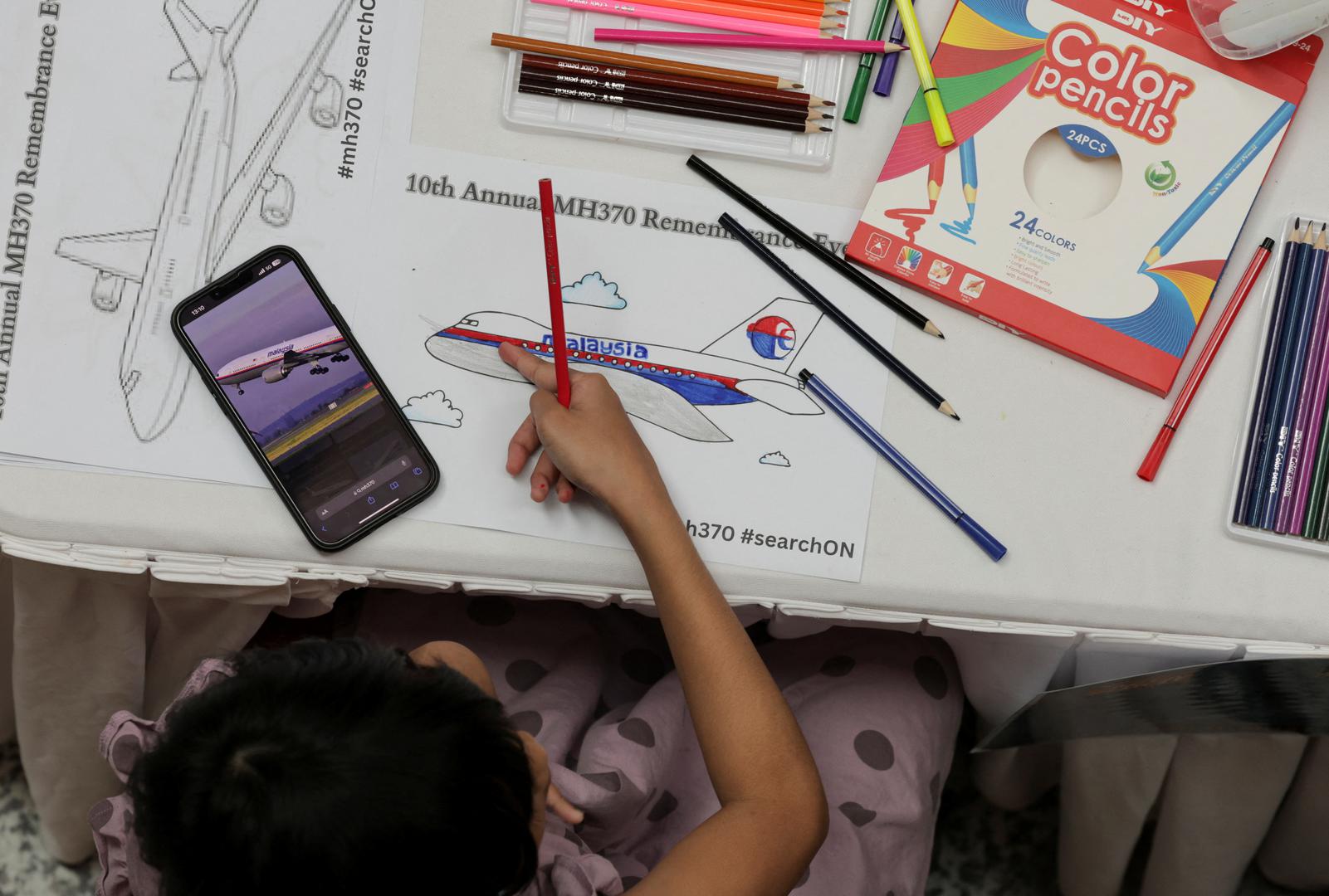 A child colours a drawing of an airplane during a remembrance event marking the 10th anniversary of the disappearance of Malaysia Airlines flight MH370, in Subang Jaya, Malaysia March 3, 2024. REUTERS/Hasnoor Hussain Photo: HASNOOR HUSSAIN/REUTERS