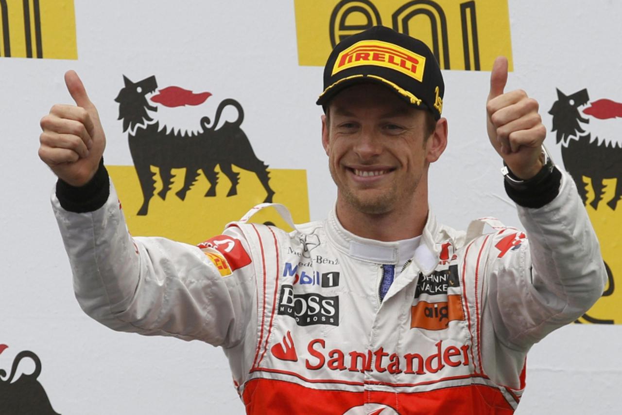 'McLaren Formula One driver Jenson Button of Britain celebrates on the podium after winning the Hungarian F1 Grand Prix at the Hungaroring circuit near Budapest July 31, 2011.                     REUT
