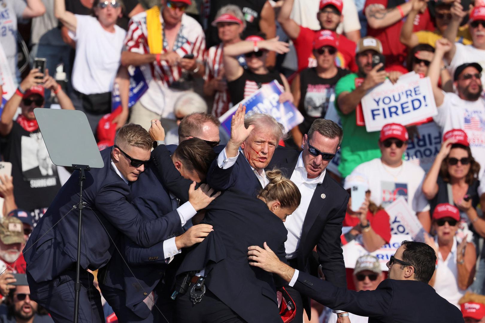 Republican presidential candidate and former U.S. President Donald Trump gestures with a bloodied face while he is assisted by U.S. Secret Service personnel after he was shot in the right ear during a campaign rally at the Butler Farm Show in Butler, Pennsylvania, U.S., July 13, 2024. REUTERS/Brendan McDermid Photo: BRENDAN MCDERMID/REUTERS