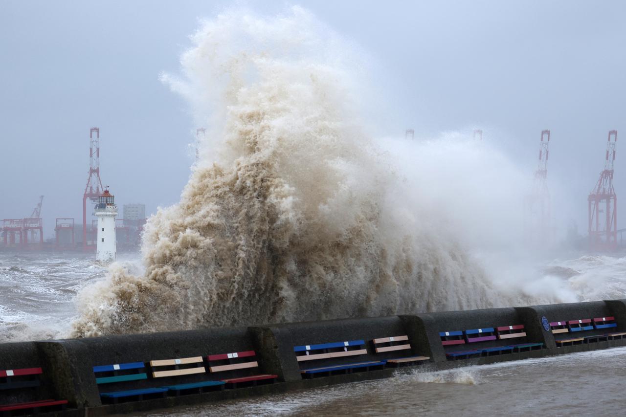 Waves crash over the sea wall during a storm at New Brighton