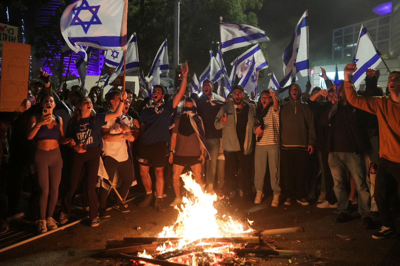 Israeli protesters chant in front of a burning fire at a demonstration against Israeli Prime Minister Benjamin Netanyahu and his nationalist coalition government's plan for judicial overhaul, in Tel Aviv, Israel, March 27, 2023. REUTERS/Itai Ron  NO RESALES. NO ARCHIVES Photo: Stringer/REUTERS