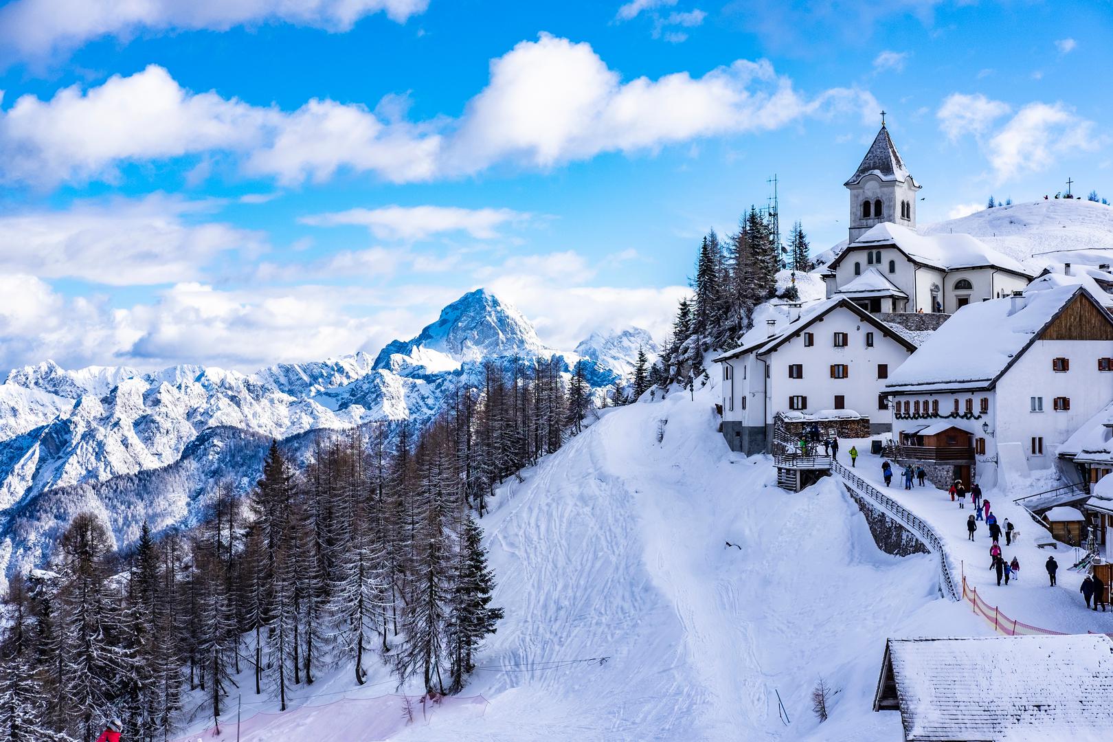 7. Monte Lussari, Italija – Duhovno utočište: Smješten visoko u Julijskim Alpama, Monte Lussari je mirno odredište poznato po skijalištima i hodočasničkoj crkvi. Posjetitelji mogu uživati u skijanju i sanjkanju na dobro održavanim stazama, te posjetiti impresivnu crkvu na vrhu planine koja pruža spektakularan pogled na okolne vrhove. Ljubitelji gastronomije mogu se okušati u furlanskim specijalitetima, među kojima se ističe ukusni topljeni sir s krumpirom, savršen za zagrijavanje nakon zimskih aktivnosti. Veljača se smatra idealnim vremenom za posjet, jer tada snježni uvjeti savršeno upotpunjuju skijašku sezonu, pružajući posjetiteljima nezaboravno iskustvo zimskog odmora u ovom duhovnom utočištu.