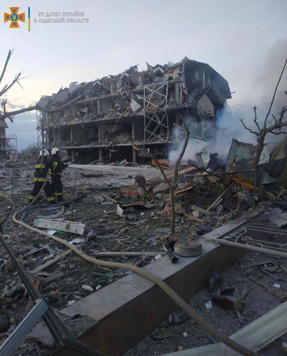 Emergency personnel work near a building damaged after a military strike, in Odesa