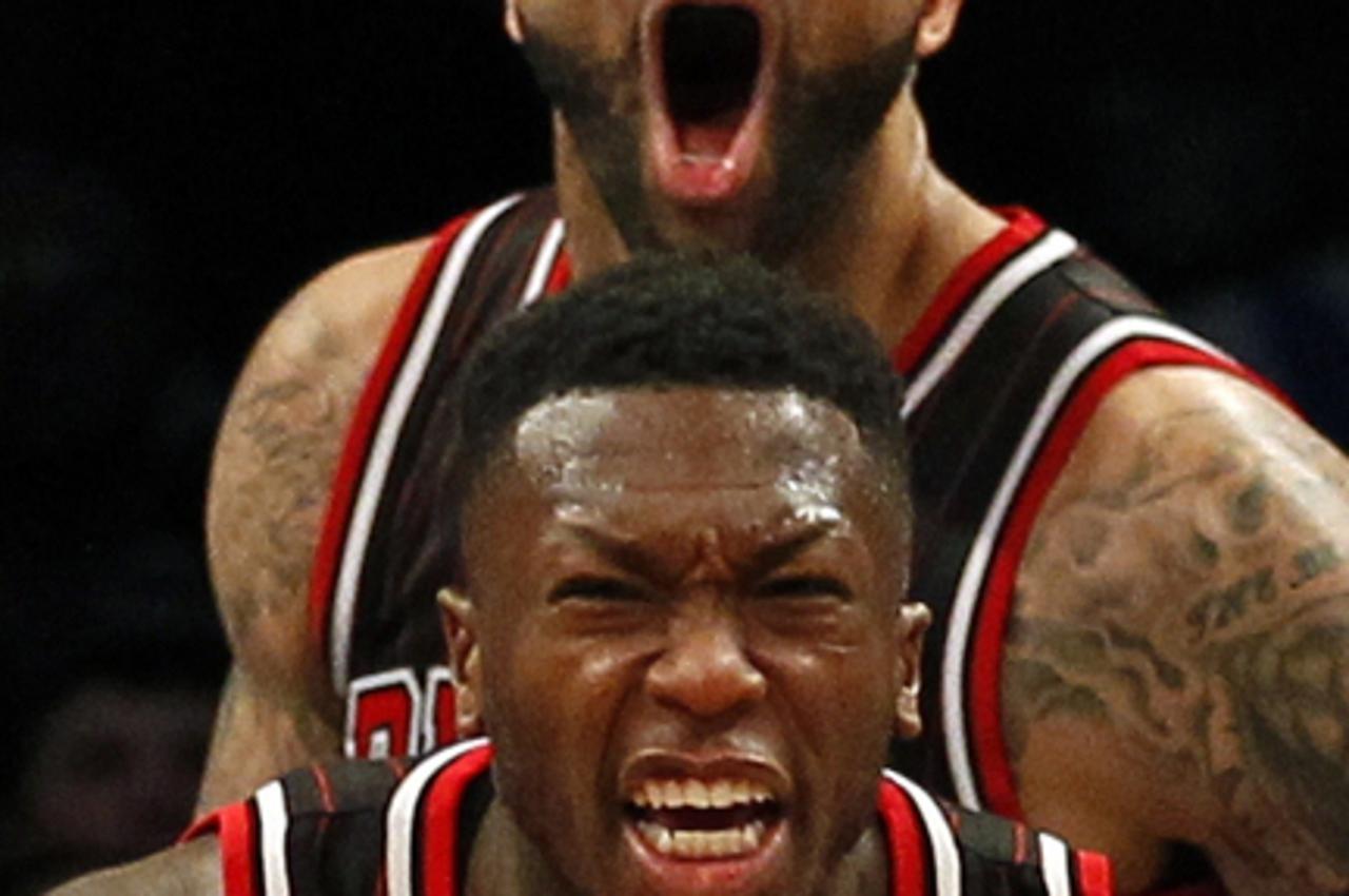 'Chicago Bulls point guard Nate Robinson and forward Carlos Boozer (top) react after Robinson made a go ahead basket against the Brooklyn Nets late in the fourth quarter of their NBA basketball game i