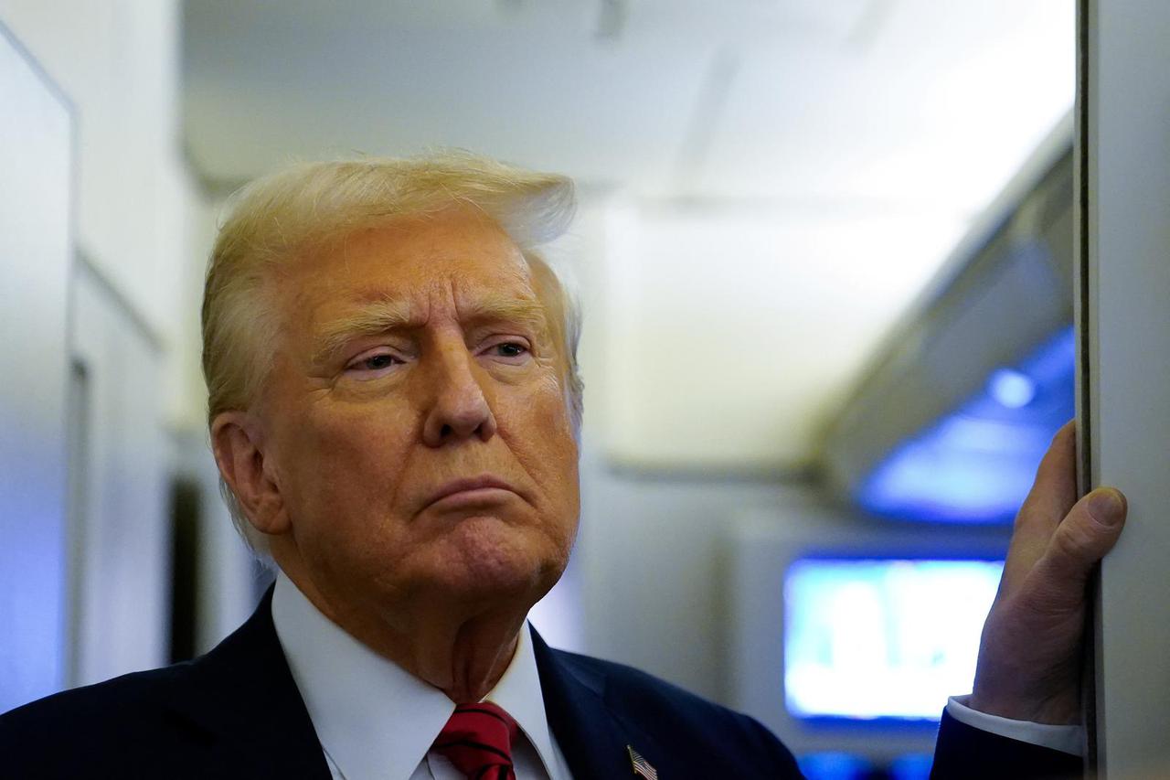 U.S. President Donald Trump speaks to reporters aboard Air Force One