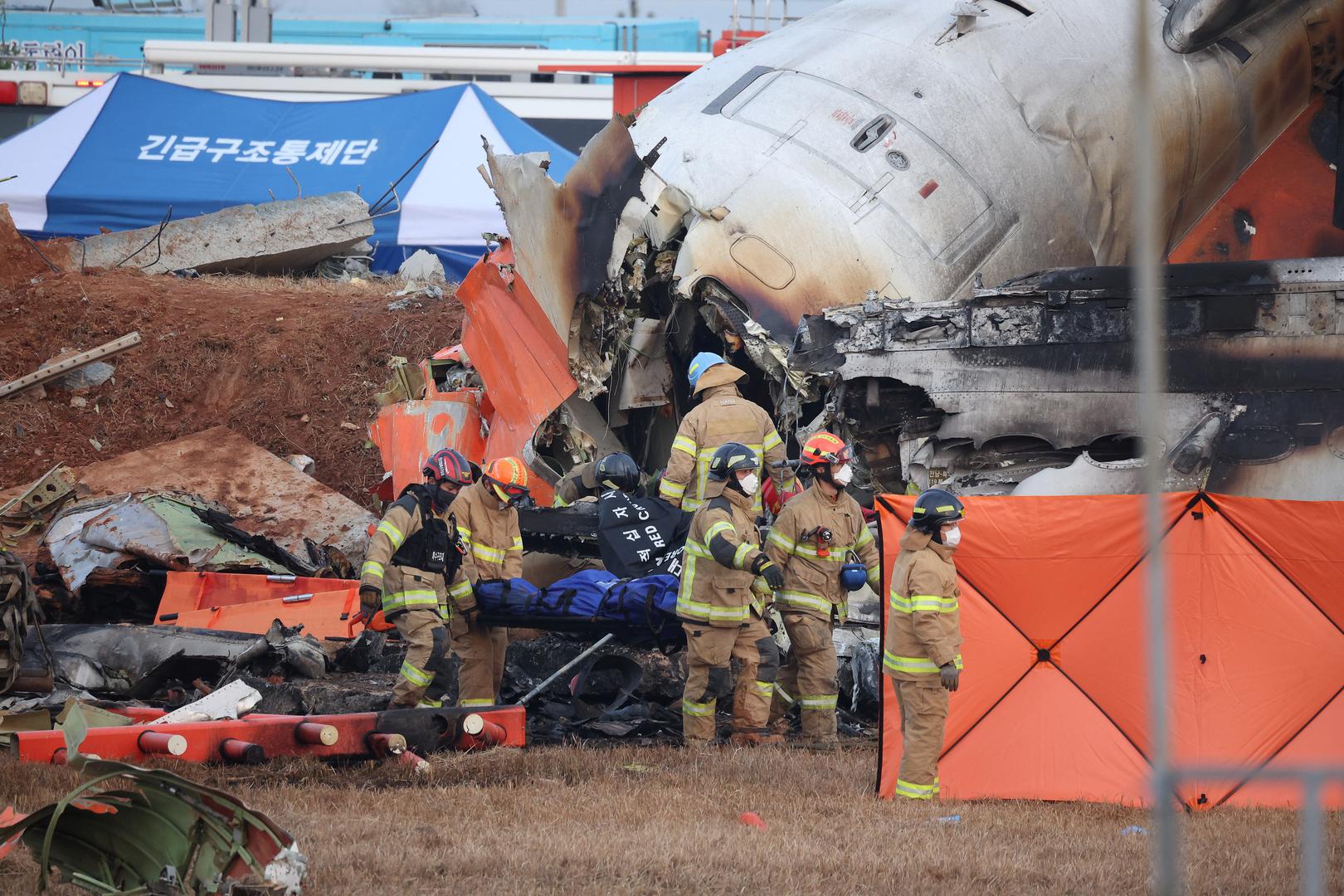 Firefighters carry the body of a passenger from the wreckage of an aircraft that crashed after it went off the runway at Muan International Airport, in Muan, South Korea, December 29, 2024. REUTERS/Kim Hong-Ji Photo: KIM HONG-JI/REUTERS