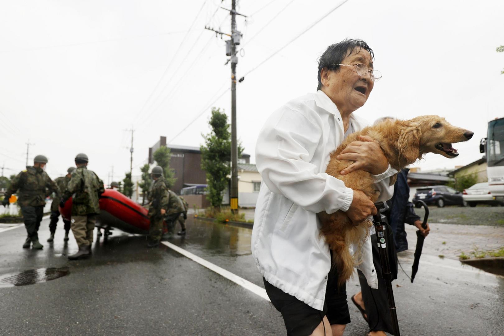 A woman is rescued with her pet dog in the flood-hit city of Omuta in Fukuoka Prefecture, southwestern Japan, on July 7, 2020, after deadly torrential rain. (Kyodo)
==Kyodo
 Photo via Newscom Newscom/PIXSELL