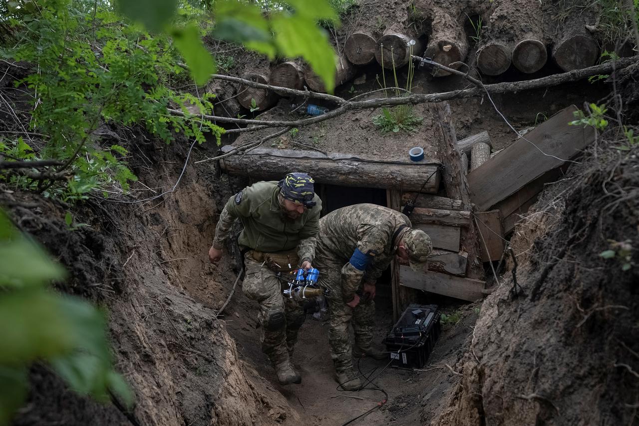 Ukrainian serviceman carries a first-person view (FPV) drone before it flies at a front line near a Russian border in a Kharkiv region