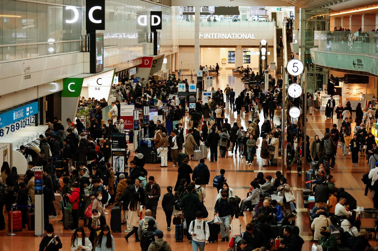 Passengers crowd at the check-in counter of Haneda International Airport in Tokyo