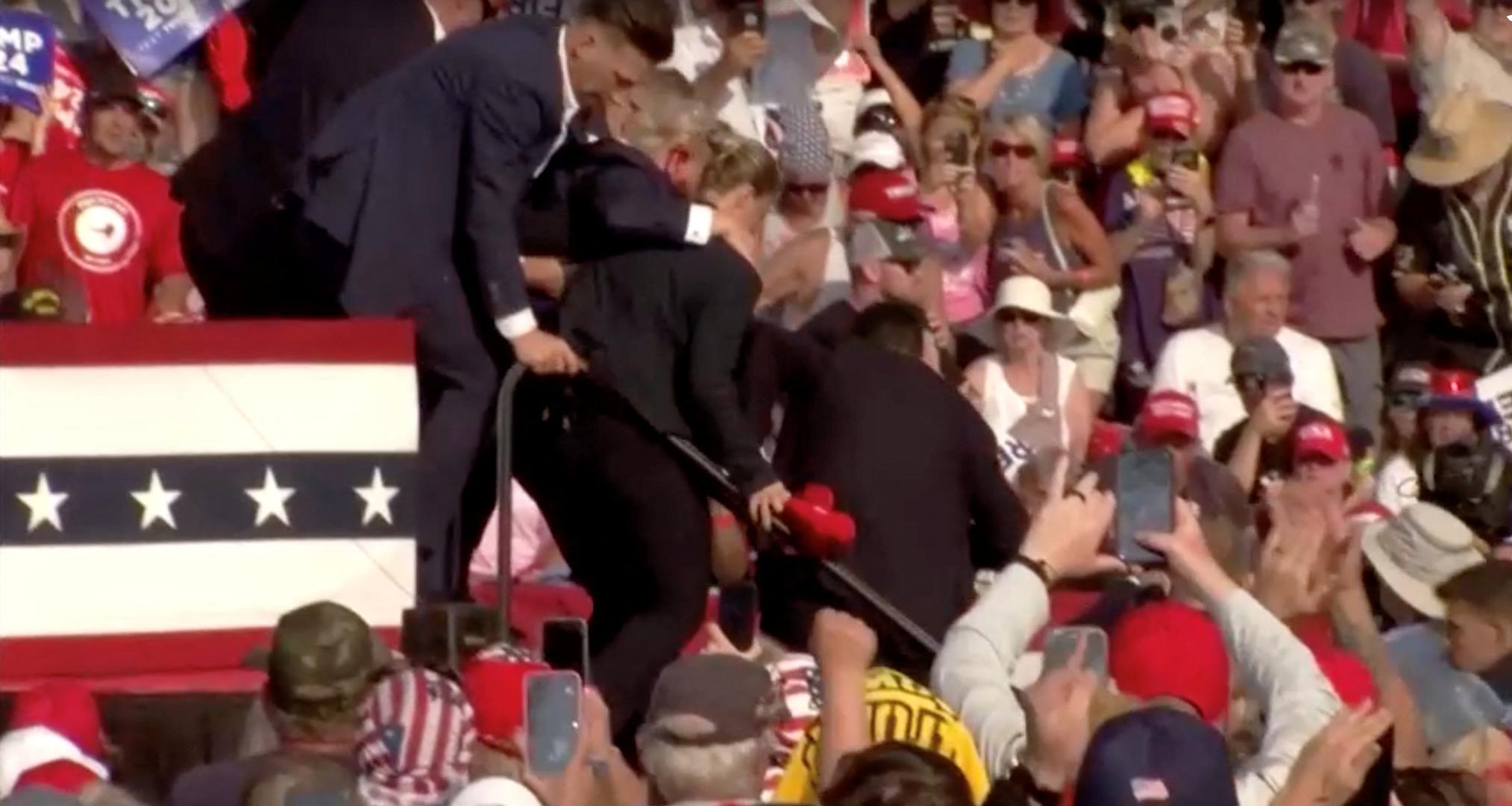 Republican presidential candidate and former U.S. President Donald Trump rushed from rally after gunfire rings out during a campaign rally at the Butler Farm Show in Butler, Pennsylvania, U.S., July 13, 2024, in this screen grab taken from a video. ABC/US Network Pool/ Handout via REUTERS ATTENTION EDITORS - THIS PICTURE WAS PROVIDED BY A THIRD PARTY. NO RESALES. NO ARCHIVES.   MANDATORY CREDIT Photo: ABC/US Network Pool/REUTERS