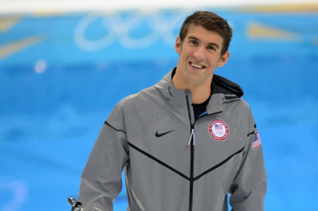 'US swimmer Michael Phelps holds his trophy of the greatest olympic athlete of all time after he won gold in the men\'s 4x100m medley relay final during the swimming event at the London 2012 Olympic G