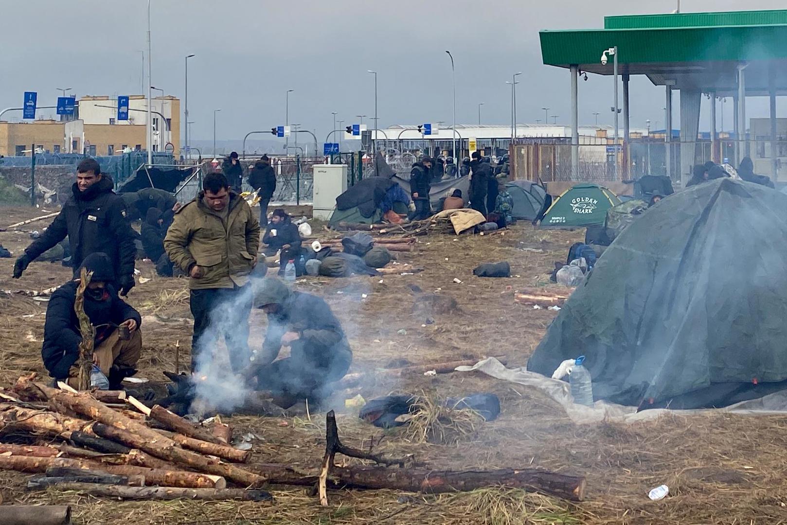 18 November 2021, Belarus, Brusgi: Migrants camp near a wooded area near the border crossing with Poland.  More and more migrants are packing their bags to move into emergency accommodation. Thousands of migrants have been holding out for days at the Belarusian-Polish border. Photo: Ulf Mauder/dpa