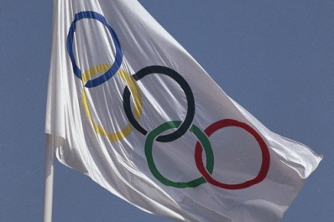 'The Olympic flame burns as a flag flutters in the breeze near the Olympic Stadium in Barcelona, July 31, 1992. (AP Photo/Mark Duncan) '