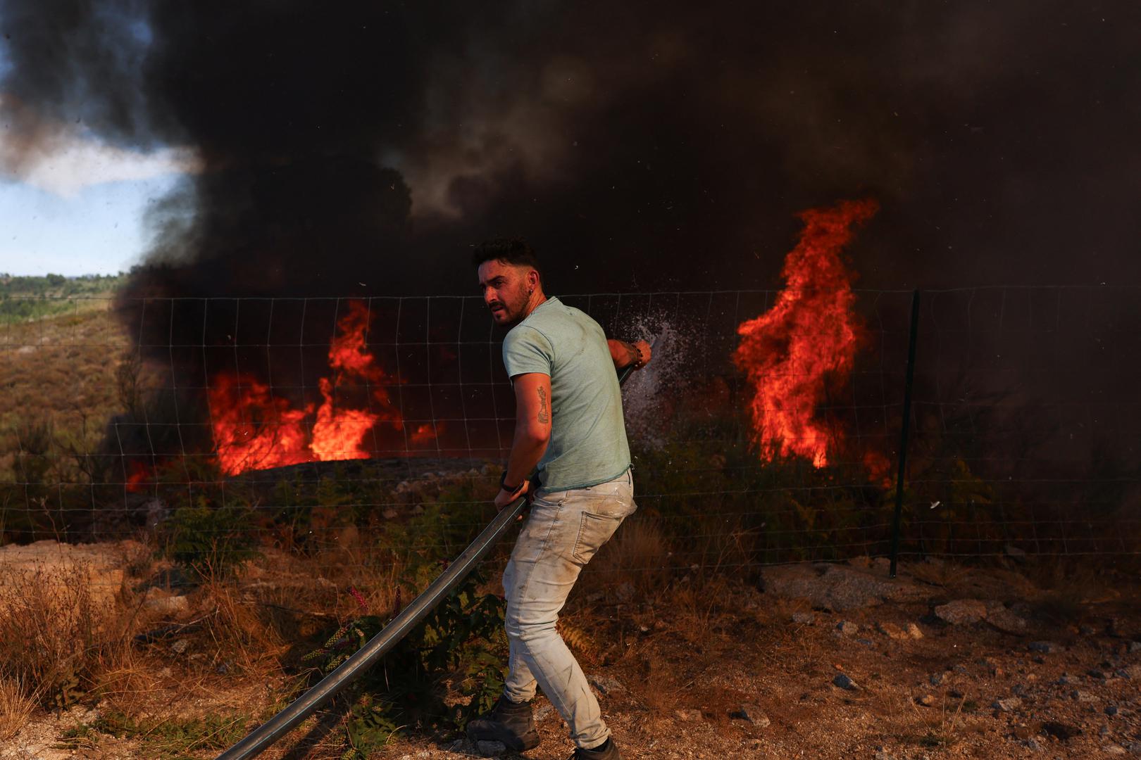 A man tries to extinguish a wildfire in Penalva do Castelo, Portugal, September 16, 2024. REUTERS/Pedro Nunes Photo: PEDRO NUNES/REUTERS