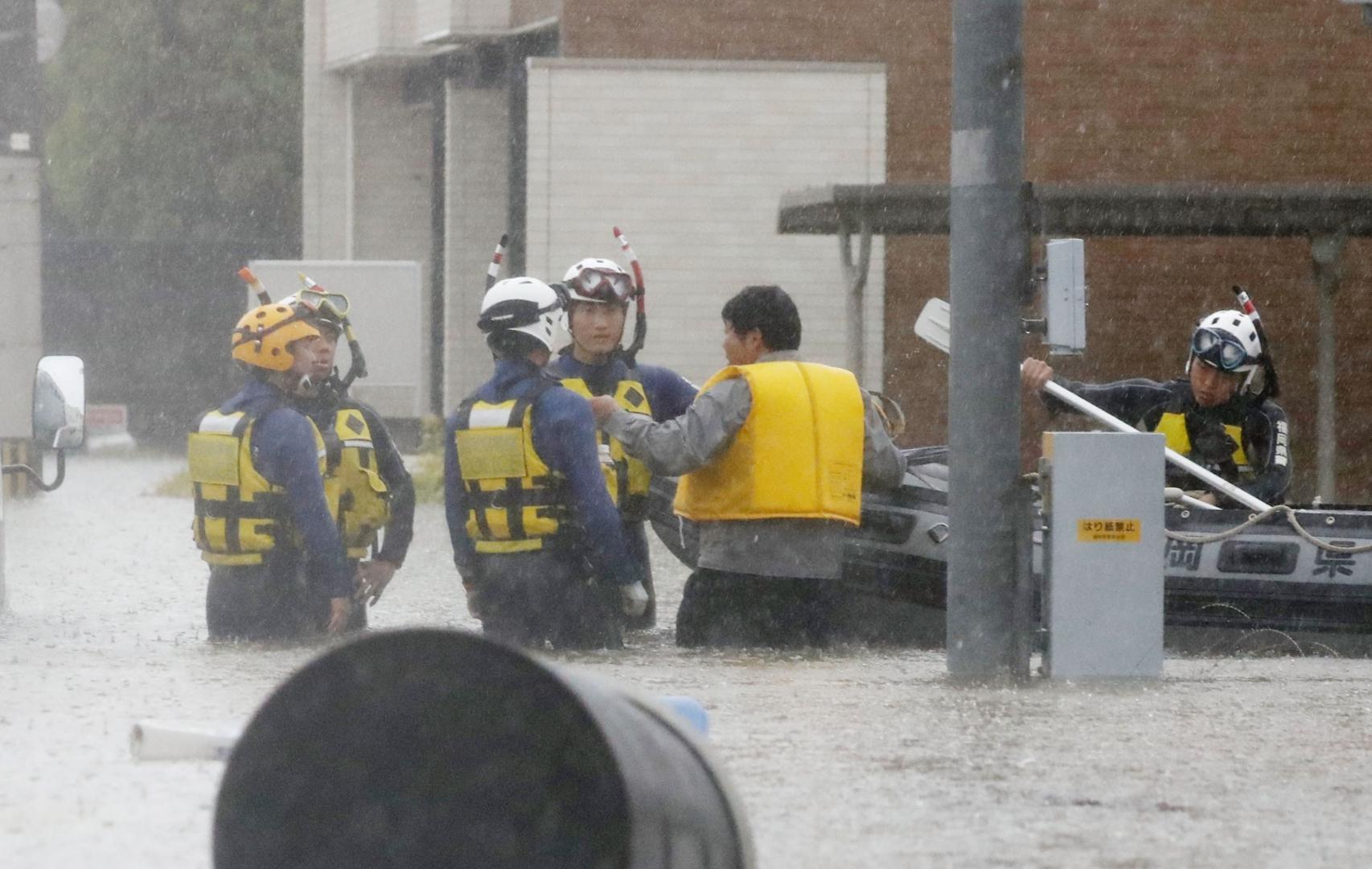 A man (2nd from R) is rescued after his car got stuck on a flooded street in Omuta, Fukuoka Prefecture, southwestern Japan, on July 7, 2020, following deadly torrential rain. (Kyodo)
==Kyodo
 Photo via Newscom Newscom/PIXSELL