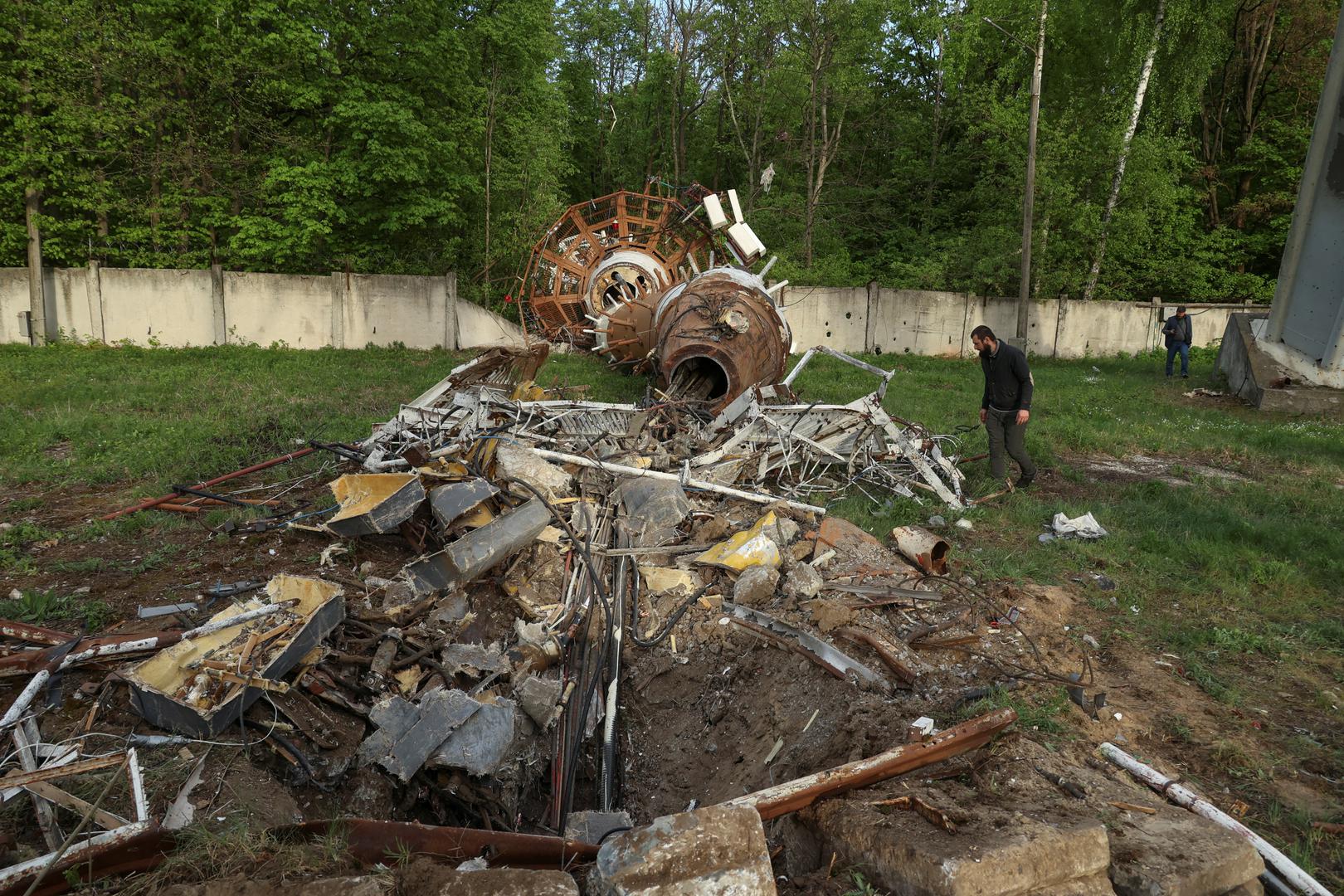 People walk next to a part of a television tower partially destroyed by a Russian missile strike, amid Russia's attack on Ukraine, in Kharkiv, Ukraine April 22, 2024. REUTERS/Sofiia Gatilova Photo: Sofiia Gatilova/REUTERS