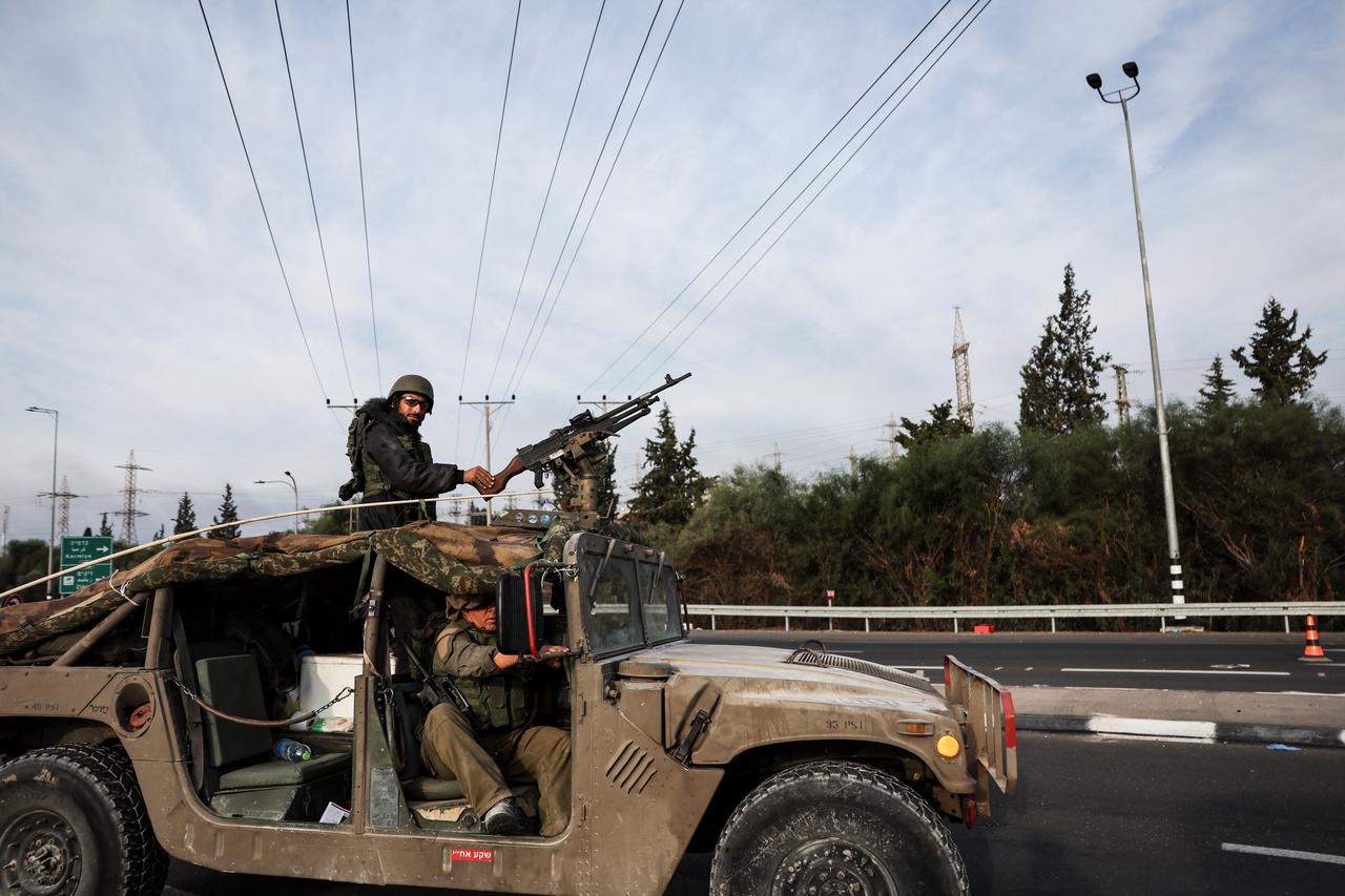 Israeli soldiers ride in a military vehicle near Israel's border with Gaza, in southern Israel