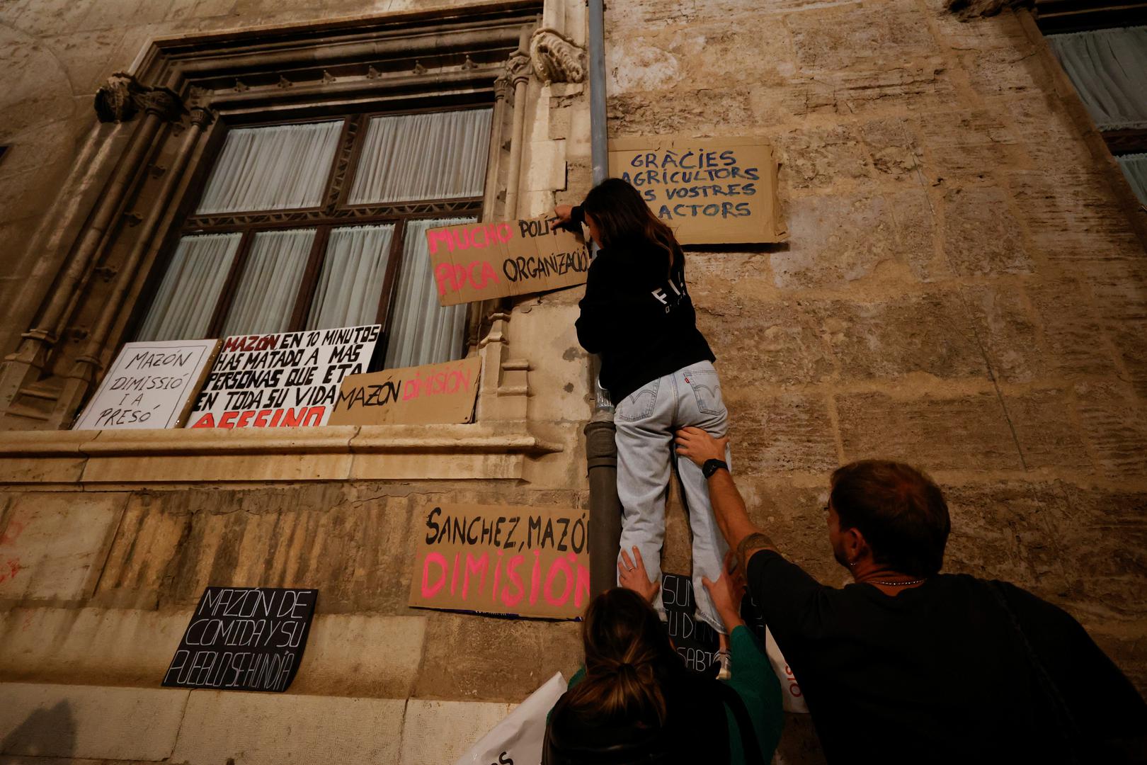 A demonstrator hangs a placard on the wall of Valencia's Regional Government Palace, as people protest against Valencia's regional leader Carlos Mazon and the management of the emergency response to the deadly floods in eastern Spain, in Valencia, Spain, November 9, 2024. REUTERS/Eva Manez Photo: Eva Manez/REUTERS