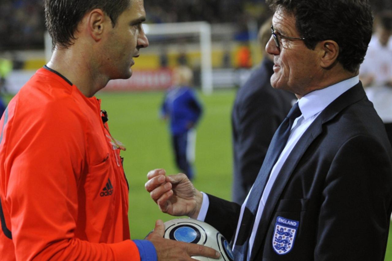 'England\'s manager Fabio Capello (R) speaks with match referee Damir Skomina after being defeated 1-0 in their World Cup 2010 qualifying soccer match against Ukraine at the Dnipro Arena in Dnipropetr