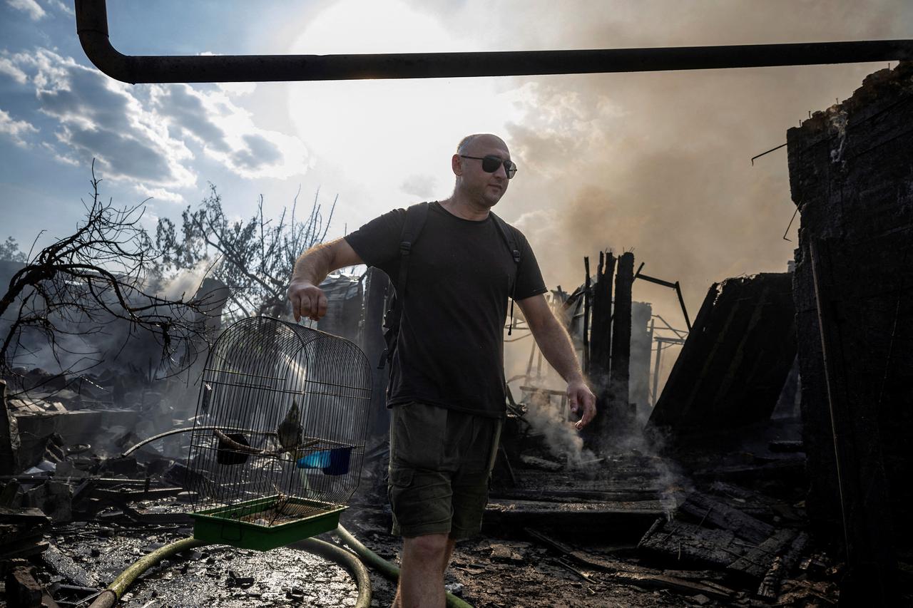 A local man rescues a pet bird from a house that was destroyed after a Russian strike on a residential area in Pokrovsk amid Russia's attack on Ukraine