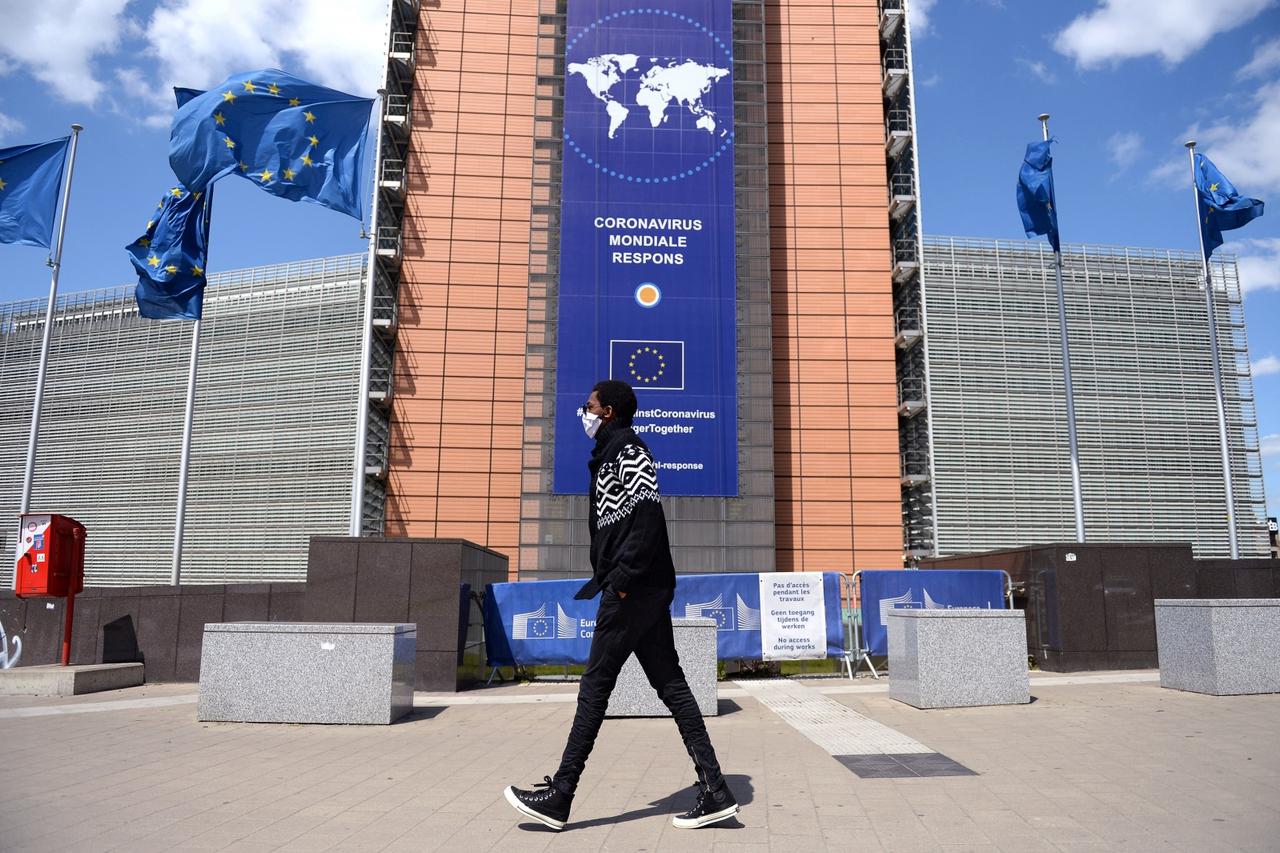 FILE PHOTO: A man wearing a face mask walks past the European Commission headquarters as the spread of coronavirus disease (COVID-19) continues in Brussels